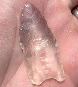 The clear quartz Clovis point in hand.